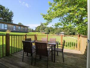 una mesa y sillas en una terraza con una valla en Willow, en Truro