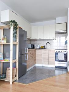 a kitchen with white cabinets and a stainless steel refrigerator at Apartament Jabłko-Mięta w Tymbarku in Tymbark