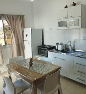 a kitchen with a wooden table and white appliances at AROMA DEL POTRERO in Potrero de los Funes