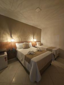 a bedroom with two beds in a room at Pousada Casa Bella in Itaberaba