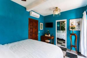 
a bedroom with a blue wall and a blue bed at Garlands Del Rio in Puerto Vallarta
