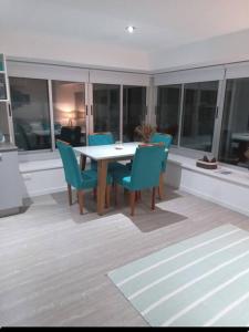 a dining room with a table and blue chairs at Apartamento nuevo in Punta del Este +2 photos