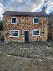 a brick house with two windows and a door at Quay Cottage in Sandwich, UK in Sandwich