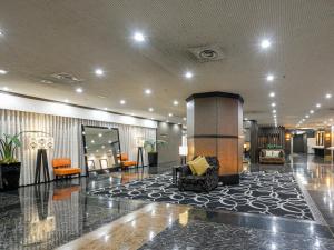a lobby with a couch and chairs in a building at APA Hotel Nagoya Sakae Ekimae EXCELLENT in Nagoya