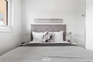 a white bedroom with a large bed with pillows at Ferienwohnung Harbour Side, App 7 Olpenitz in Olpenitz