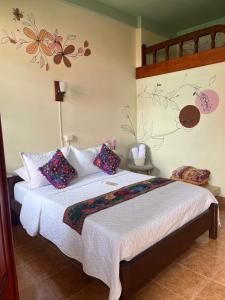 a bedroom with a bed with flowers on the wall at Candileja Hostel in Jardin