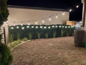a patio with a bunch of lights and plants at Duży domek na Polnej in Konin