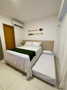 sypialnia z dużym białym łóżkiem z dwiema poduszkami w obiekcie Flat Makia Beach Experience 120C - Muro Alto - Porto de Galinhas w mieście Cupe