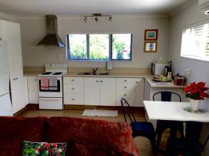 a kitchen with a couch and a table in a room at Bethlehem Garden Retreat in Tauranga