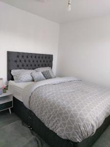 ラグビーにあるModern Entire 3-Bedroom House in Rugbyの白い壁のベッドルームのベッド1台