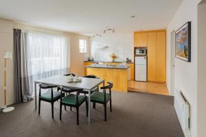 a kitchen and dining room with a table and chairs at Quest Cathedral Junction Serviced Apartments in Christchurch