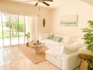 a living room with a white couch and a ceiling fan at Beachfront Breathtaking Views Puerto Aventuras in Puerto Aventuras