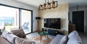 TV a/nebo společenská místnost v ubytování Les Rivages de Stagnola Appartement T3 vue mer et montagne plage 200m climatisé