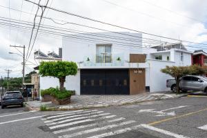 a white building with a garage in a parking lot at Cute and Efficient close to Antigua Guatemala Exit H6 in Guatemala