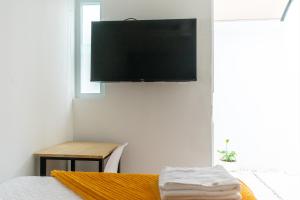 a bedroom with a flat screen tv hanging on the wall at Cute and Efficient close to Antigua Guatemala Exit H6 in Guatemala