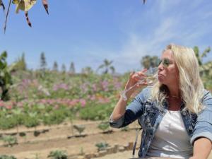 a woman drinking a glass of wine in a garden at Baja Tranquilo - Villas Cerritos in El Pescadero