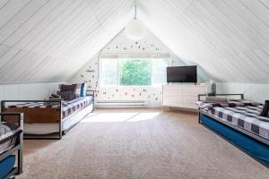 une chambre mansardée avec deux lits et une télévision dans l'établissement Updated 3 BDR Gas Fire Place BBQ, à Albrightsville