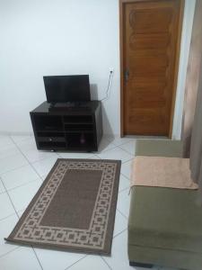 a living room with a television and a door at Apê 05 confortável perto de tudo in Vitória da Conquista