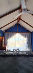 un letto con ventilatore a soffitto e finestra di Beach Camp Bed & Breakfast a Gili Sudak