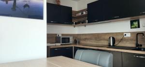Una cocina con gabinetes negros y una mesa y sillas. en Le Senghor, en Courcouronnes 11 fotos más