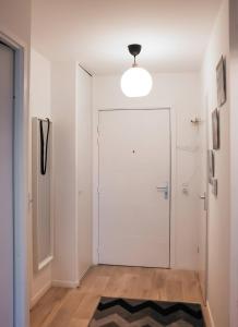 un pasillo con una puerta blanca y una alfombra en Le Senghor, en Courcouronnes