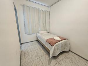 a small bedroom with a bed and a window at Hotel Rex in Lages