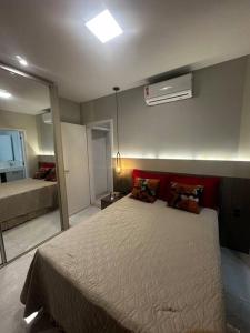 a bedroom with a large bed and a mirror at Apartamento 203 Maré cheia Praia de Bombas in Bombinhas +8 photos