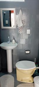 a bathroom with a sink and a toilet and a mirror at Suíte para a Oktoberfest in Blumenau
