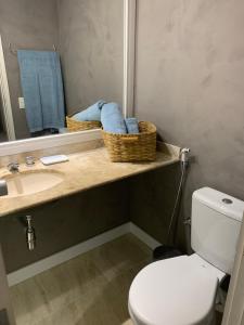 a bathroom with a sink and a toilet and a mirror at Flat Leblon inn in Rio de Janeiro