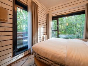 a bedroom with a bed and a large window at Lushwood A Forest Retreat in Antoing +32 photos