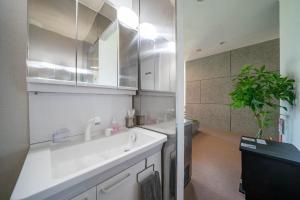 un bagno bianco con lavandino e doccia di The Kokage a Nakafurano