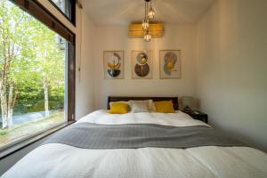 una camera da letto con un letto e una grande finestra di The Kokage a Nakafurano Altre 185 foto