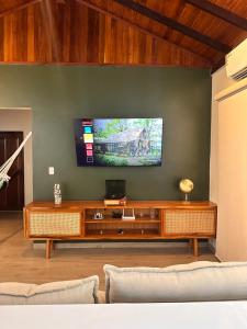 a living room with a television on a green wall at Ap Pérola do Tapajos in Santarém