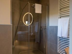 um banheiro com chuveiro, pia e espelho em Serene Bungalow Getaway em Antoing mais 32 fotografias