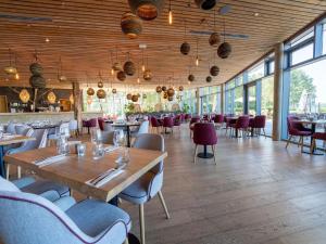 a dining room with tables and chairs and windows at Lakeside Lovely Stay, Antoing in Antoing