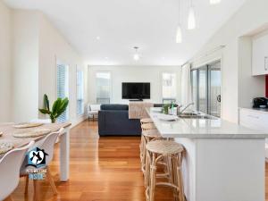 维克多港Light Filled Modern & Stylish 3BR Holiday Home的厨房以及带大台面的起居室。