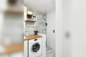 a laundry room with a washer and dryer at Arabella in Nelson Bay