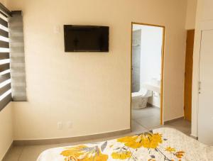a bedroom with a flat screen tv on the wall at House with pool near Riviera Nayarit beaches in Los Algodones
