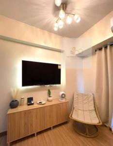 a living room with a flat screen tv on a wall at Homestayed ilo in Iloilo City +2 photos