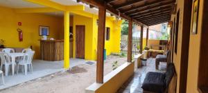 a house with yellow walls and a patio at Vila do Chaves in Itaúnas