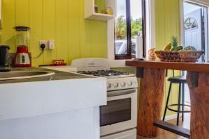 Una cocina con una estufa blanca y un fregadero. en Montete Cottages, en Choiseul