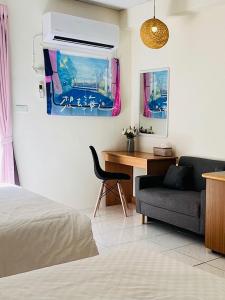 a bedroom with a bed and a couch and a desk at Sister Leis Home Zhiben Hot Spring in Wenquan
