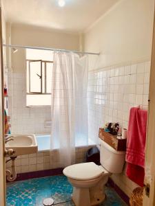 a bathroom with a toilet and a sink and a tub at Acogedora Habitación en el Centro Histórico, CDMX in Mexico City