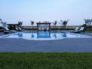 una piscina con sillas y una jaula en el medio en Villa Fenice, en Calatabiano