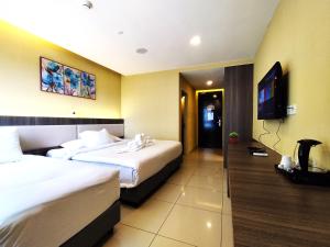 a hotel room with two beds and a flat screen tv at Genting GetawayStayCationHut AT Ion Delemen in Genting Highlands +39 photos