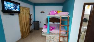 a room with a bunk bed and a television at Buzios Posada in Chichiriviche