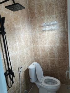 Un baño con inodoro y pared de azulejos. en ZG Villa Batu, en Tlekung 7 fotos más