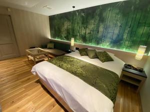 a bedroom with a bed and a large painting on the wall at ホテル郷GO男塾ホテルグループAdult Only in Yamatokoriyama