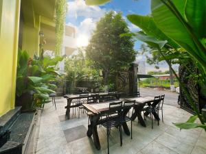 a patio with wooden tables and chairs and plants at Thi Boutique Villa in Danang