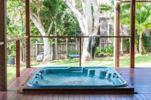 eine Whirlpool-Badewanne auf einer Terrasse mit Fenster in der Unterkunft Casa Del Lago - Oceanstays - Lakehouse in Yamba